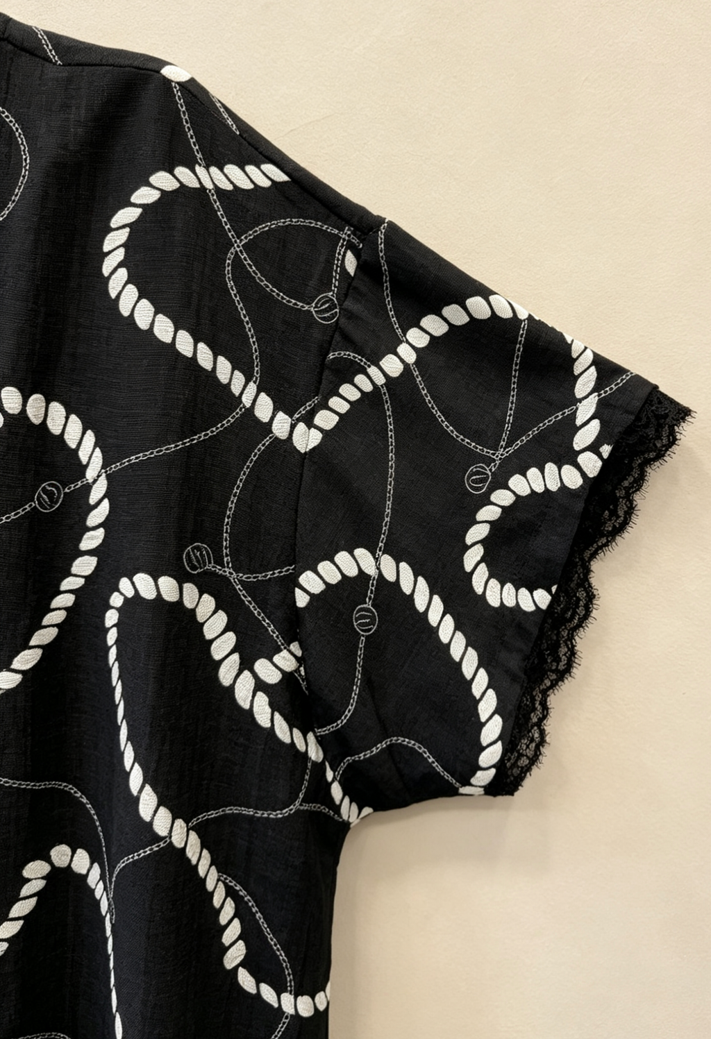 Schwarz-Weiße Bluse in Großen Größen, Kurzarm-Oberteil mit Kettendruck, V-Ausschnitt mit Spitzenborte am Saum und an den Ärmeln, Schicke Sommerbluse für Damen in Großen Größen, Elegantes Freizeit-T-Shirt in Übergröße 46-60 2WH639